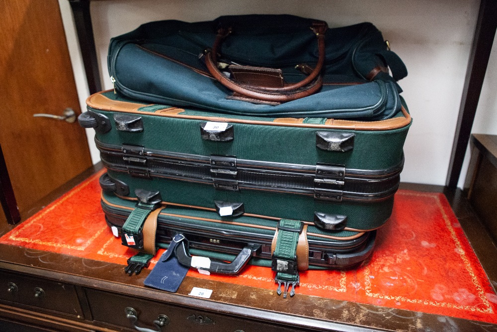 A SET OF THREE ANTLER GREEN CANVAS AND LEATHER SUITCASES AND A LARGE HOLDALL