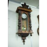 A VIENNA STYLE WALL CLOCK, THE PEDIMENT WITH CLASSICAL HEAD OVER CARVED PILASTERS, GLAZED FRONT