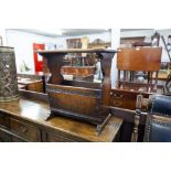 A REPRODUCTION OAK MAGAZINE RACK/COFFEE TABLE, THE SOLID TOP OVER SHAPED ENDS