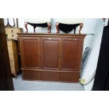 A LARGE MAHOGANY THREE DOOR TELEVISION AND STEREO CABINET, RAISED ON BUN FEET