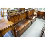 AN EARLY TWENTIETH CENTURY OAK PEW, THREE SEATER WITH TONGUE AND GROOVE BACK OVER HINGED SEAT AND