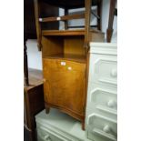 A WALNUTWOOD BEDSIDE CUPBOARD WITH CONCAVE FRONT