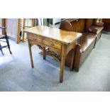 AN EDWARDIAN OAK CARD TABLE, THE HINGE TOP REVEALING SHELL LOW RELIEF CARVING, OVER TWO DRAWERS,