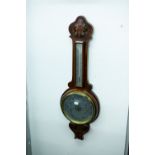 AN EARLY TWENTIETH CENTURY CARVED WALNUTWOOD BANJO BAROMETER AND THERMOMETER