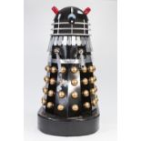 BLACK, SILVER AND GOLD PAINTED MANUFACTURED BOARD AND FIBREGLASS MODEL OF A DALEK, with white