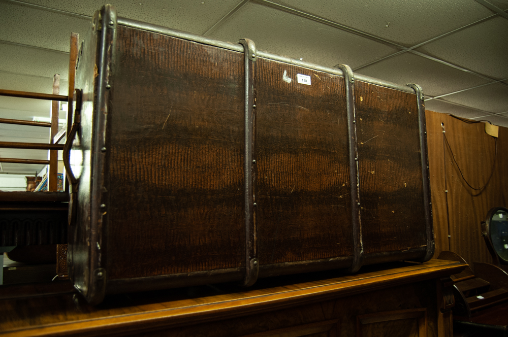 A LEATHER BOUND TRAVELLING TRUNK, WITH END HANDLES