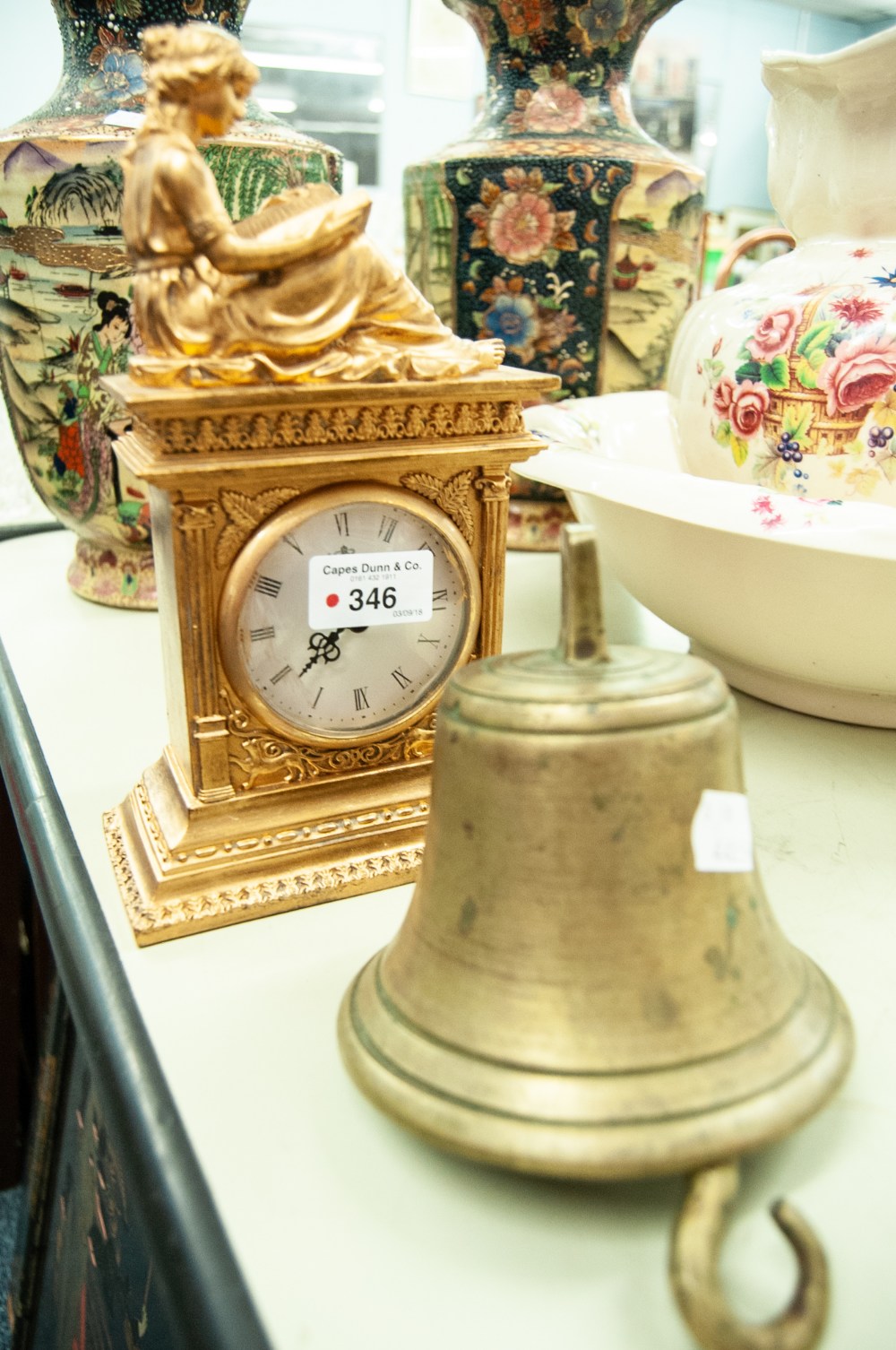 ORIENTAL LACQUERED PANEL, A GILT CASED CLOCK AND A BRASS BELL