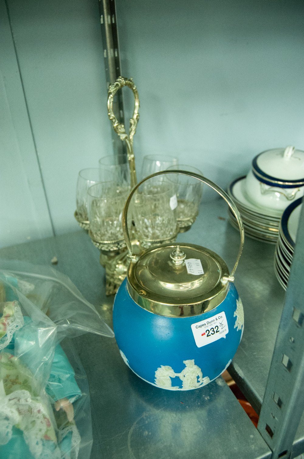 A SILVER PLATE DRINKING GLASS HOLDER, THE SIX CUT GLASSES, RAISED ON PIERCED TRAYS WITH OVERHEAD