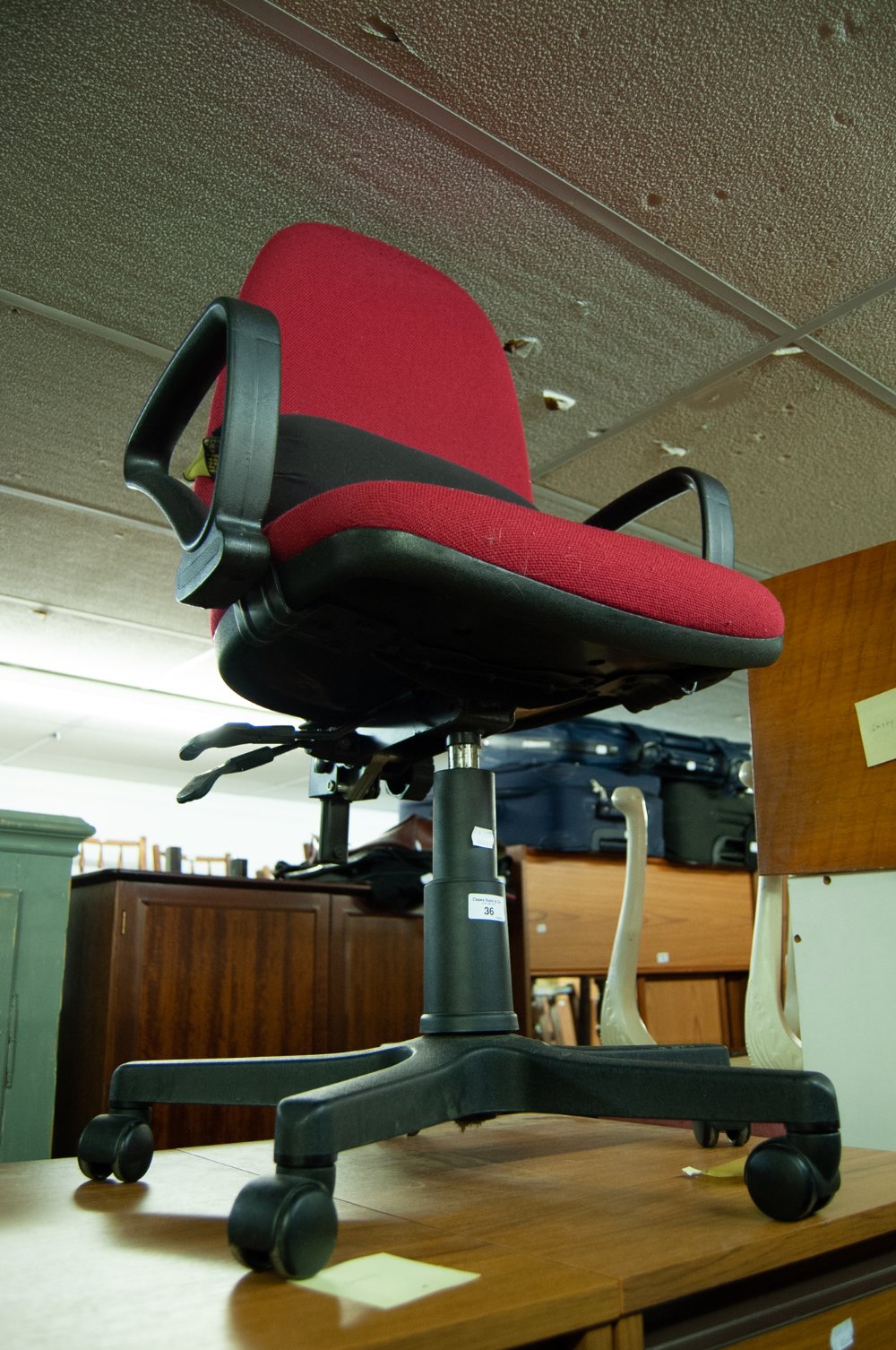 AN OFFICE REVOLVING ARMCHAIR, IN CRIMSON FABRIC