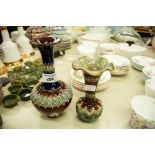 TWO DOULTON LAMBETH MOULDED POTTERY GLOBE AND SHAFT VASES, each with flared rim, one decorated