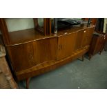 A LATE 1950's/EARLY 60's WALNUTWOOD VENEERED SERPENTINE FRONTED SIDEBOARD, WITH PULL-OUT MAPLE LINED