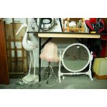 A WHITE PAINTED CIRCULAR CHEVAL TOILET MIRROR AND A BLACK WROUGHT IRON TABLE LAMP AND A STORK