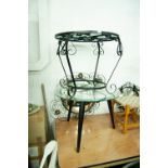 A BLACK WROUGHT IRON CIRCULAR COFFEE TABLE WITH GLASS TOP AND A SIMILAR CONVEX WALL MIRROR AND