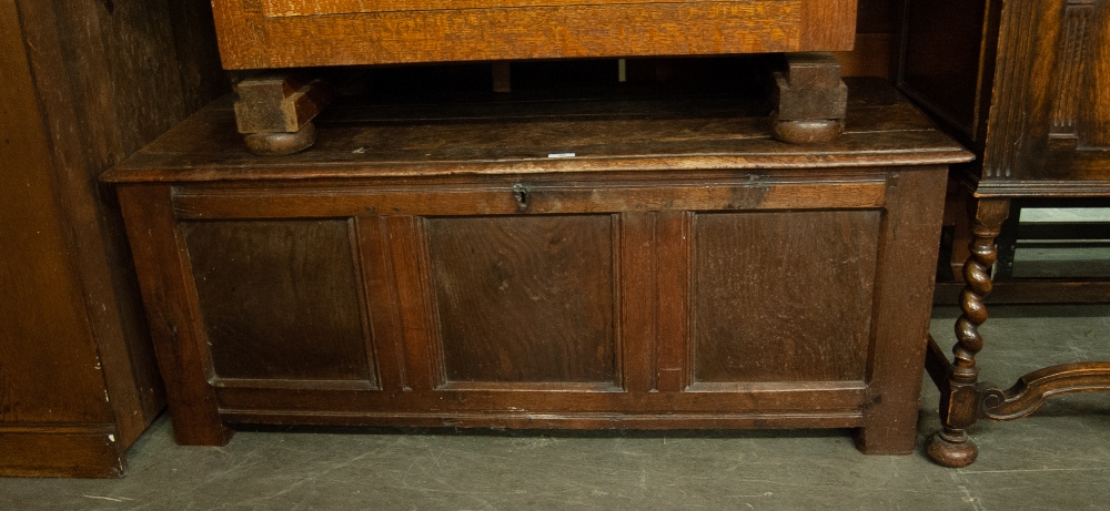 AN ANTIQUE OAK COFFER WITH THREE PANEL FRONT (A.F.)