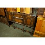 A REPRODUCTION OAK SIDEBOARD WITH RAISED BACK, END CUPBOARDS AND TWO CENTRAL DRAWERS, ALL RAISED