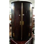 GEORGE III MAHOGANY BOW FRONTED HANGING CORNER CUPBOARD WITH BRASS BUTTERFLY HINGES