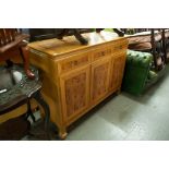 A REVOLVING BOOKCASE AND A MODERN LIGHT WOOD SIDEBOARD, HAVING THREE CENTRAL DRAWERS AND CUPBOARDS