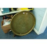 AN ANTIQUE INDIAN ENGRAVED BRASS TRAY, ON ASSOCIATED WOODEN STAND