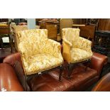 TWO UPHOLSTERED TUB CHAIRS, RAISED ON OAK LEGS WITH CARVING TO THE FRONT (2)