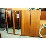 PAIR OF AUSTINSUITE TEAK WARDROBES, EACH WITH CENTRE MIRROR PANEL FLANKED BY TWO SLIDING DOORS AND A