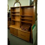 A TEAK OPEN BOOKCASE/DISPLAY CABINET ABOVE CUPBOARD AND TWO DRAWER BASE