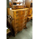 A REPRODUCTION MAHOGANY SERPENTINE FRONT BEDROOM CHEST OF NINE DRAWERS ON SPLAYED BRACKET FEET