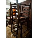 A PAIR OF OAK REPRODUCTION DINING CHAIRS, PAD BACK AND SEAT WITH STUD DETAIL AND CUP AND COVER