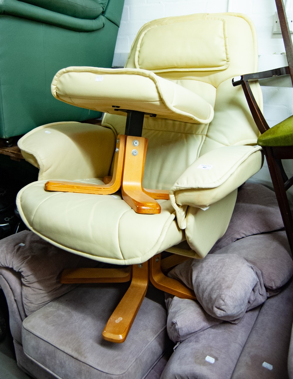 CREAM HIDE REVOLVING AND RECLINING EASY ARMCHAIR AND MATCHING FOOTSTOOL, ON LIGHT BEECH WOOD FOUR