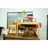 A CHILD'S WOODEN PUSH-ALONG BIKE WITH PAINTED SEAT, A CHILD'S TABLE AND CHAIRS SET AND A CHILD'S