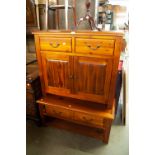 A MODERN MAHOGANY FINISH STAINED WOOD CUPBOARD WITH TWO DRAWERS OVER PANELLED DOORS AND A SIMILAR