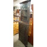 A NINETEENTH CENTURY CARVED DARK OAK DOUBLE CORNER CUPBOARD WITH GLAZED DOOR ABOVE