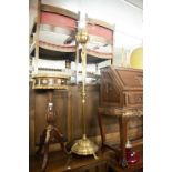 A BRASS OIL LAMP WITH RED GLASS SHADE OVER BRASS WELL ON SPREAD BASE WITH PAW FEET