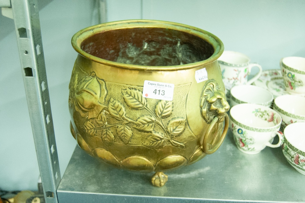EMBOSSED BRASS JARDINIERE, with captive lion mask handles and three claw and ball feet