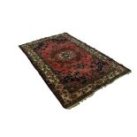 TABRIZ PERSIAN RUG with centre circular medallion with pendants on a wine red field, midnight blue