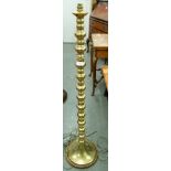 A BRASS STANDARD LAMP, SILK SHADE OVER SQUAT BRASS BALL SPACER COLUMN, ON SPREAD BASE