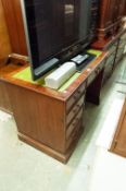 A REPRODUCTION SINGLE PEDESTAL KNEEHOLE DESK WITH GREEN LEATHER INSET TOP WITH GILT DETAIL