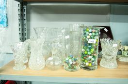 THREE CUT GLASS FLOWER VASES, A PURPLE GLASS LARGE 'BRANDY BALLOON' VASE AND A GLASS CYLINDRICAL