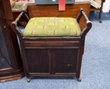 AN EDWARDIAN MAHOGANY PIANO STOOL WITH END RAISED HANDLES, OVER CUPBOARD BASE