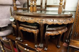 AN EARLY 20TH CENTURY LACQUERED ORIENTAL HARDWOOD HIGH RELIEF CARVED NEST OF SEVEN TABLES, EACH WITH