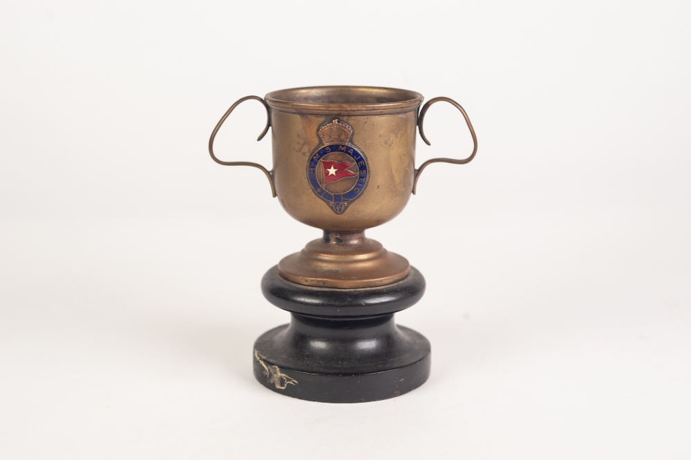 A WHITE STAR LINES R.M.S. MAJESTIC BRASS TWO HANDLED TROPHY CUP, on wooden stand, 4 1/2" (11.5cm)