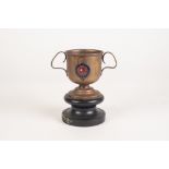 A WHITE STAR LINES R.M.S. MAJESTIC BRASS TWO HANDLED TROPHY CUP, on wooden stand, 4 1/2" (11.5cm)