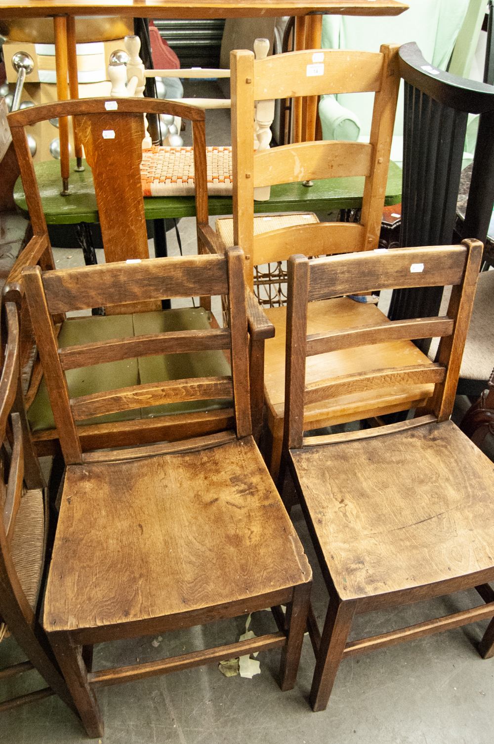 AN OAK CARVED ARMCHAIR AND A PAIR OF HARDWOOD SINGLE CHAIRS WITH LADDER BACKS AND PANEL SEATS AND