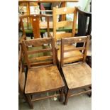 AN OAK CARVED ARMCHAIR AND A PAIR OF HARDWOOD SINGLE CHAIRS WITH LADDER BACKS AND PANEL SEATS AND