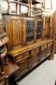 JACOBEAN STYLE OAK DINING ROOM SUITE HAVING TRESTLE DINING TABLE ON CUP AND COVER SUPPORTS, SIX