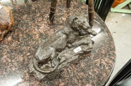 A SIGNED AND NUMBERED BRONZED RESIN RECUMBENT LION FIGURINE W. TINIYAN ?