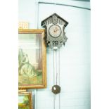 A BLACK FOREST CUCKOO CLOCK OF TRADITIONAL FORM WITH PINE CONE WEIGHTS, PENDULUM AND A SMITHS ART