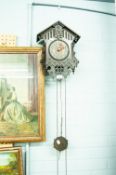 A BLACK FOREST CUCKOO CLOCK OF TRADITIONAL FORM WITH PINE CONE WEIGHTS, PENDULUM AND A SMITHS ART