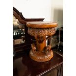 A MODERN PEDESTAL TABLE, HAVING CIRCULAR TREE TRUNK TOP OVER CARVED WALKING ELEPHANT RING