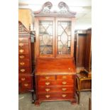 A REPRODUCTION MAHOGANY BUREAU BOOKCASE, THE TOP WITH ASTRAGAL GLAZED DOORS ENCLOSING TWO WOODEN