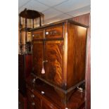 A REPRODUCTION FLAME MAHOGANY CABINET, TWO SHORT AND OVER TWO DOOR CUPBOARD WITH GLASS PROTECTOR TOP